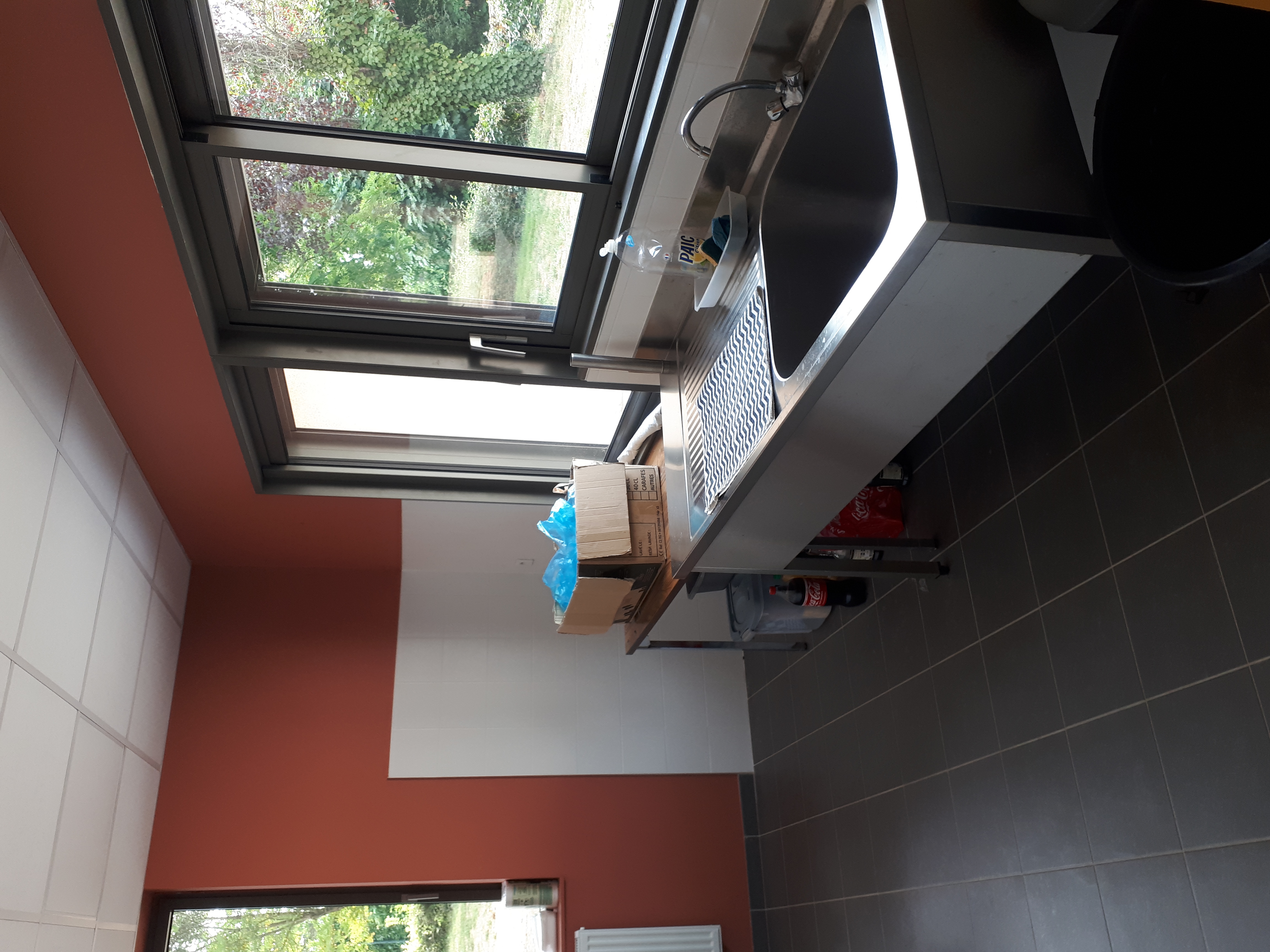 la cuisine avec sur la partie vitr&eacute;e l'acc&egrave;s &agrave; la buvette donnant sur la terrasse